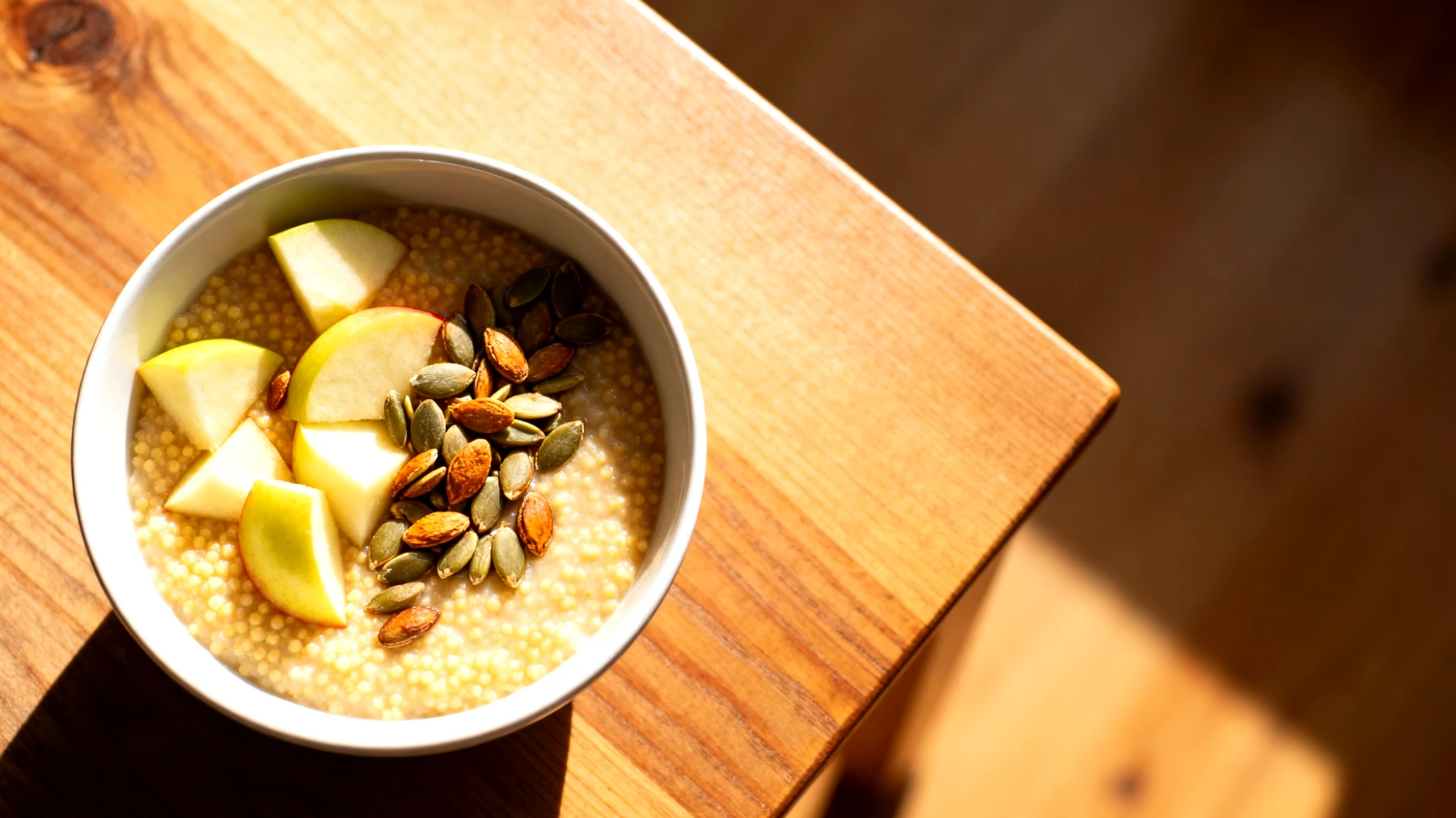 Hirse-Porridge mit gerösteten Kürbiskernen und Apfelstücken"